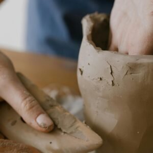 Close-up of hands shaping a clay pot, showcasing the art of pottery making.
