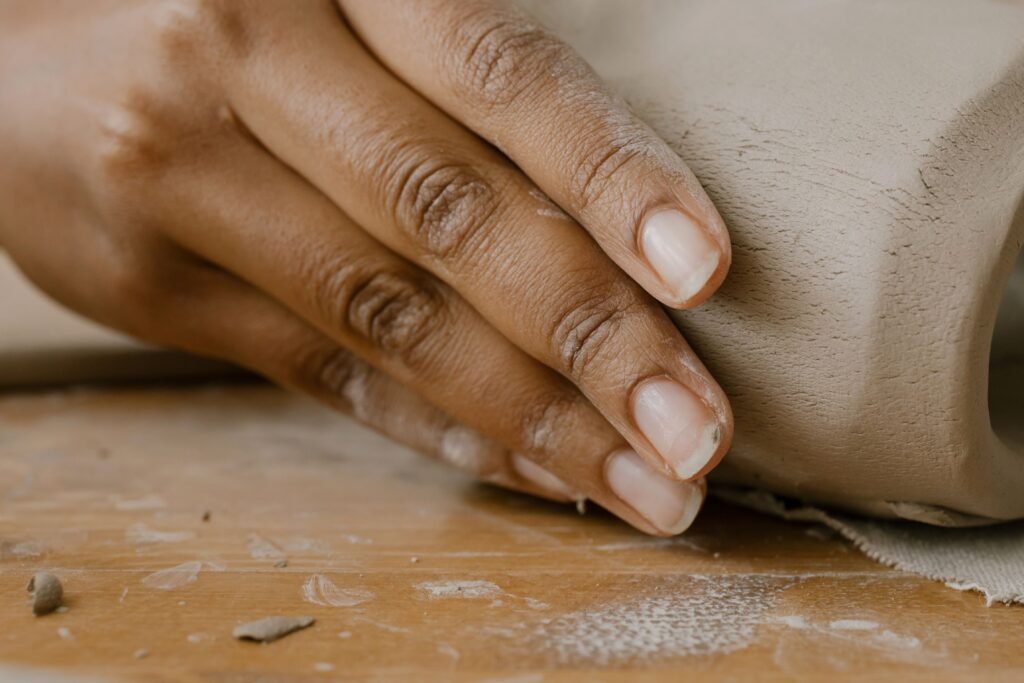 A detailed close-up of hands molding clay showcasing craftsmanship and creativity.